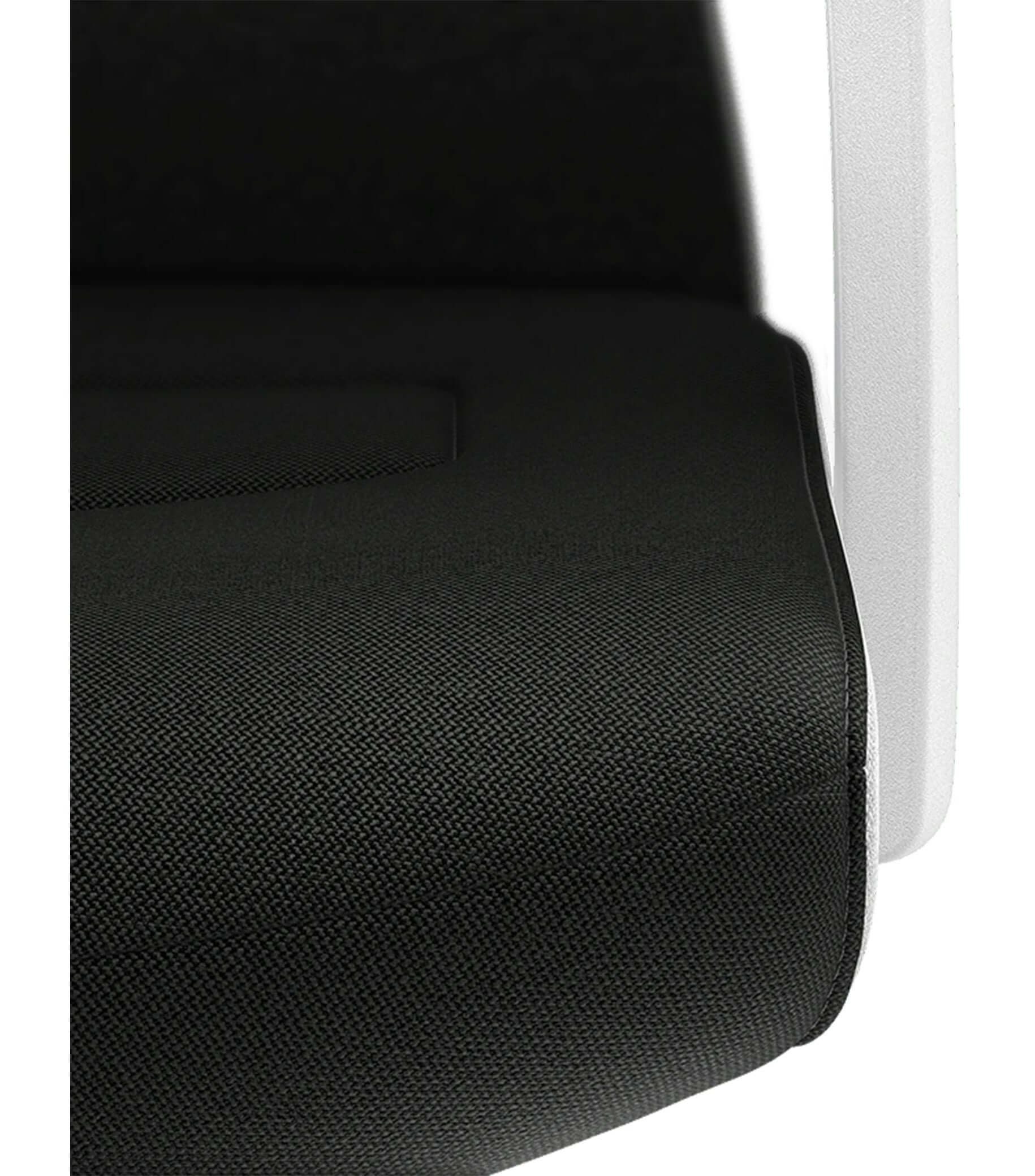 Close-up of PURE Interior Edition #07 chair with padded black Era upholstery and white frame, featuring Smart-Spring technology.