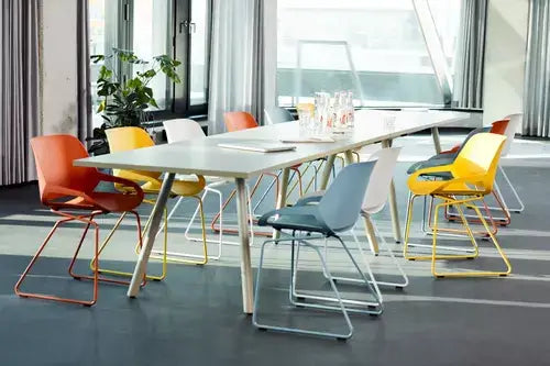 Modern office space with colorful Numo active chairs arranged around a sleek conference table.