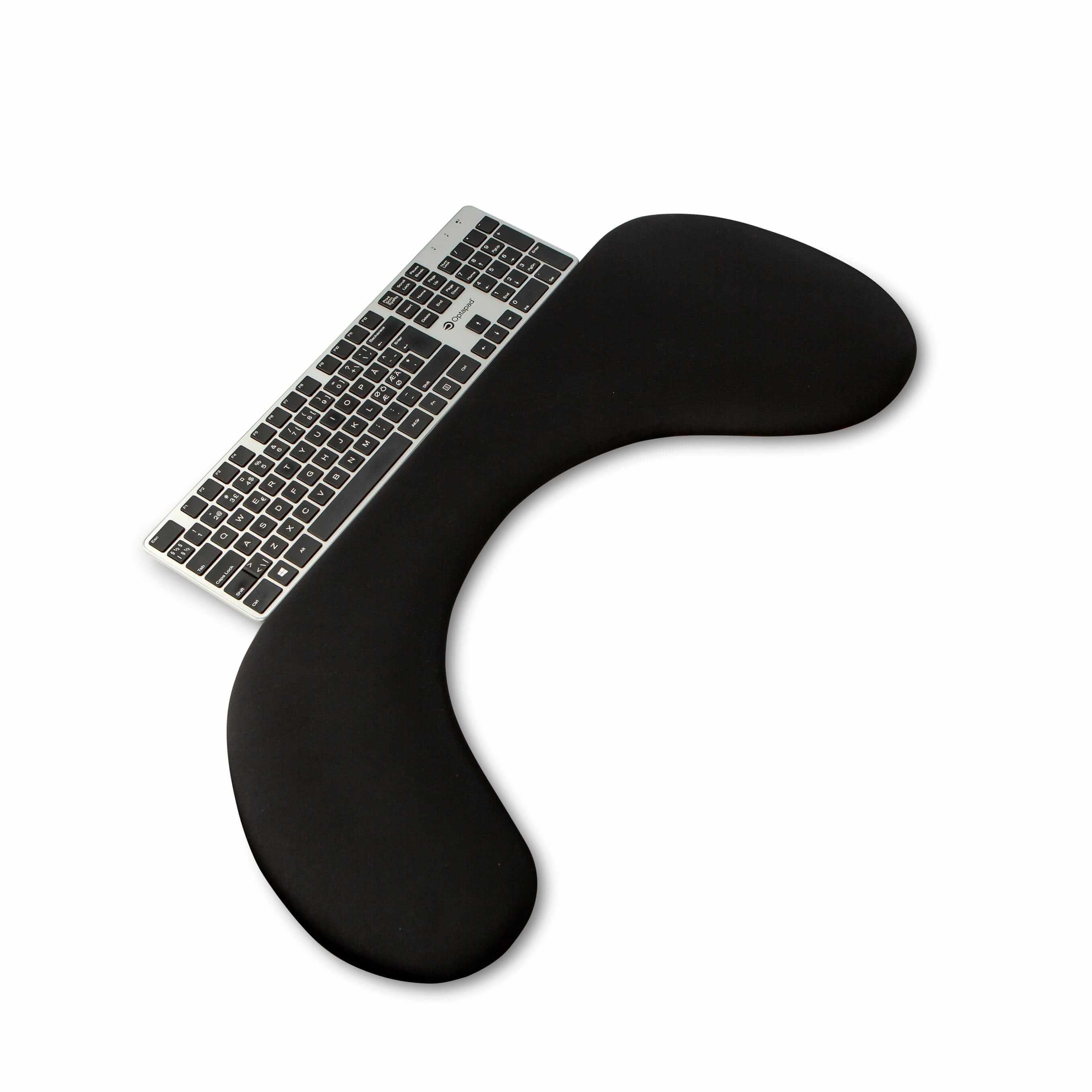 Ergonomic asymmetric arm support in black artificial leather on a desk with a keyboard, designed to relieve shoulder and neck pain.