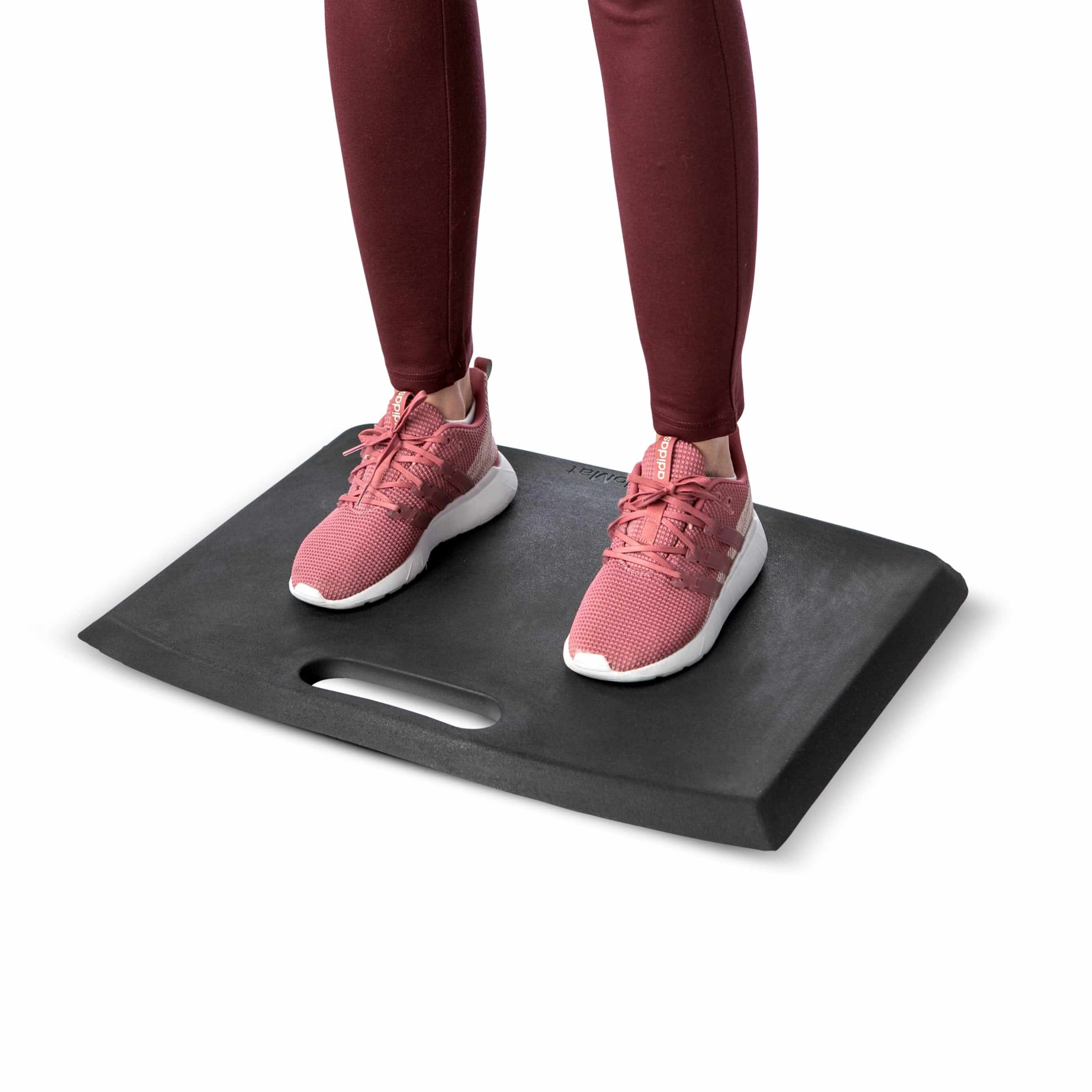 Person standing on grey GetUpMat workstation mat with carrying handle, providing ergonomic comfort and support.