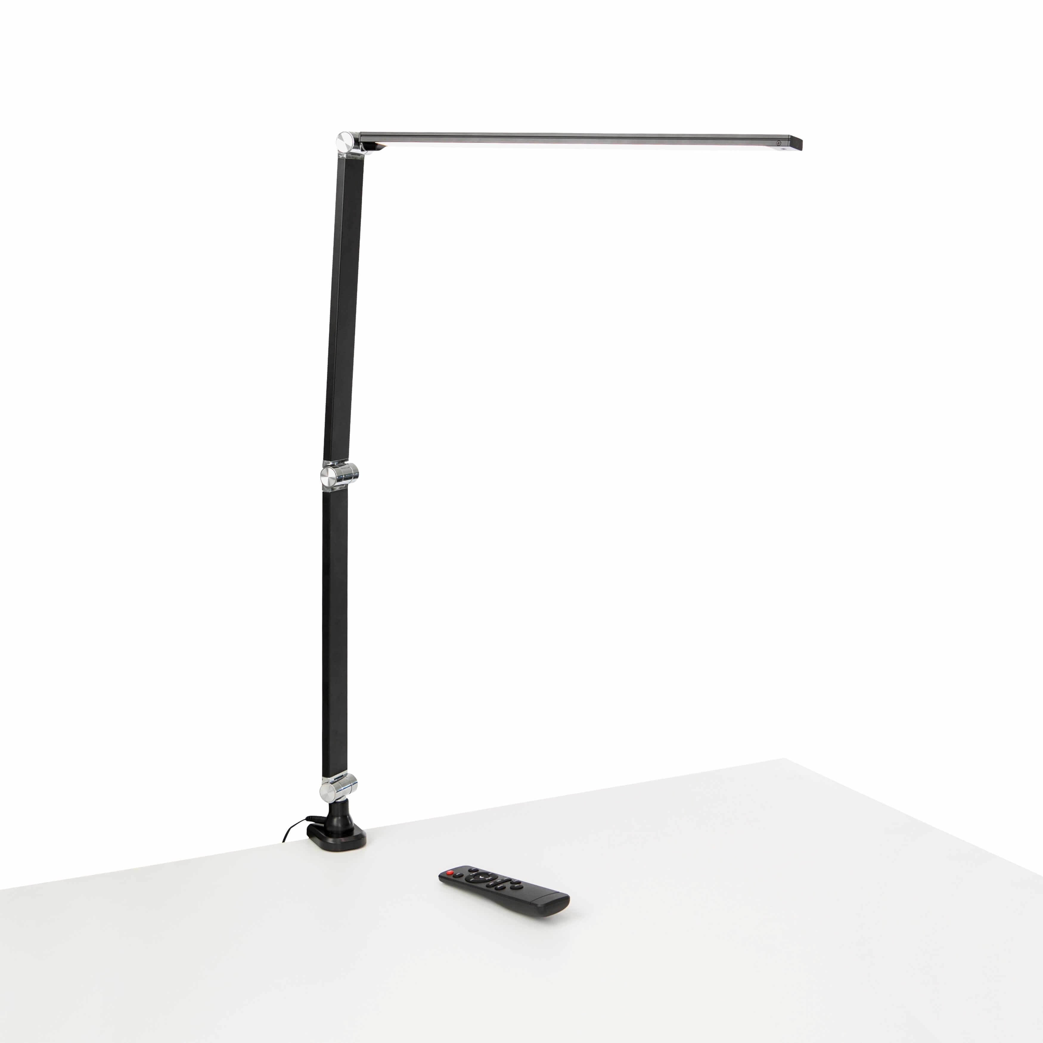 Black Link LED desk lamp with remote on a white desk.