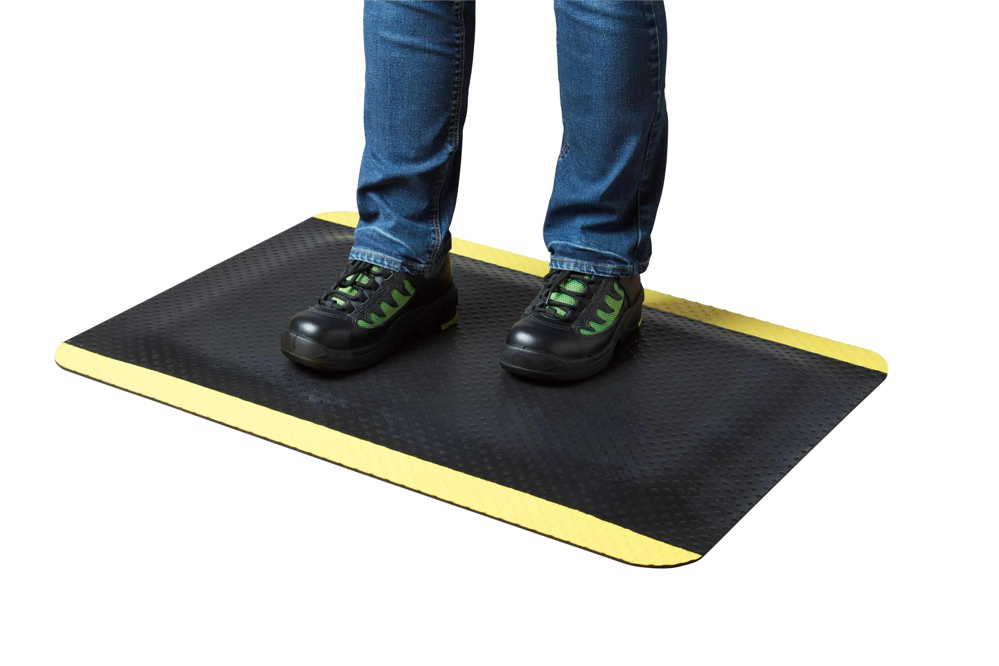 Industrial mat with person standing, showcasing comfort and safety, suitable for both dry and damp environments.