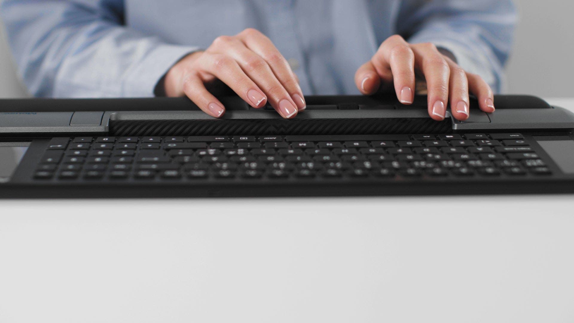 Person using Delta Regular grey keyboard with wide control bar for seamless use, 4000 dpi resolution, and six programmable buttons.