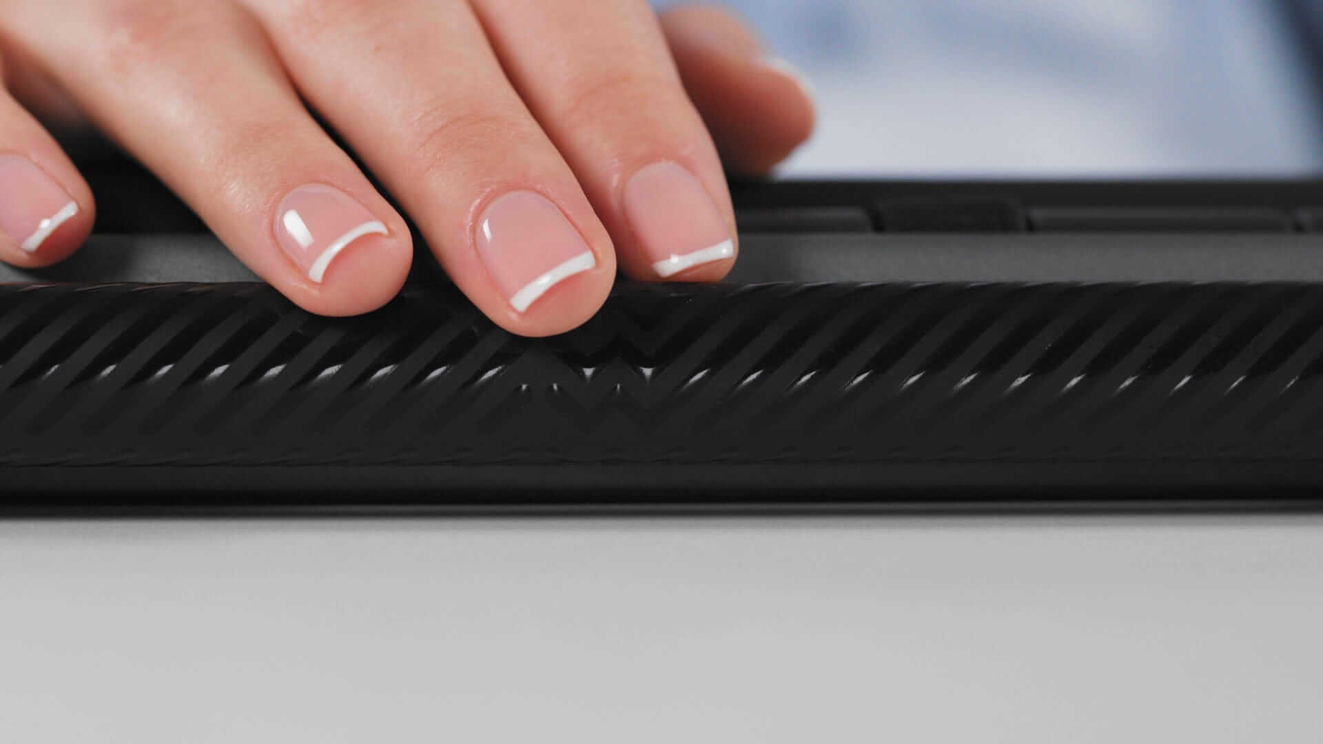 Hand resting on Delta Regular black control bar designed for ergonomic keyboard use.