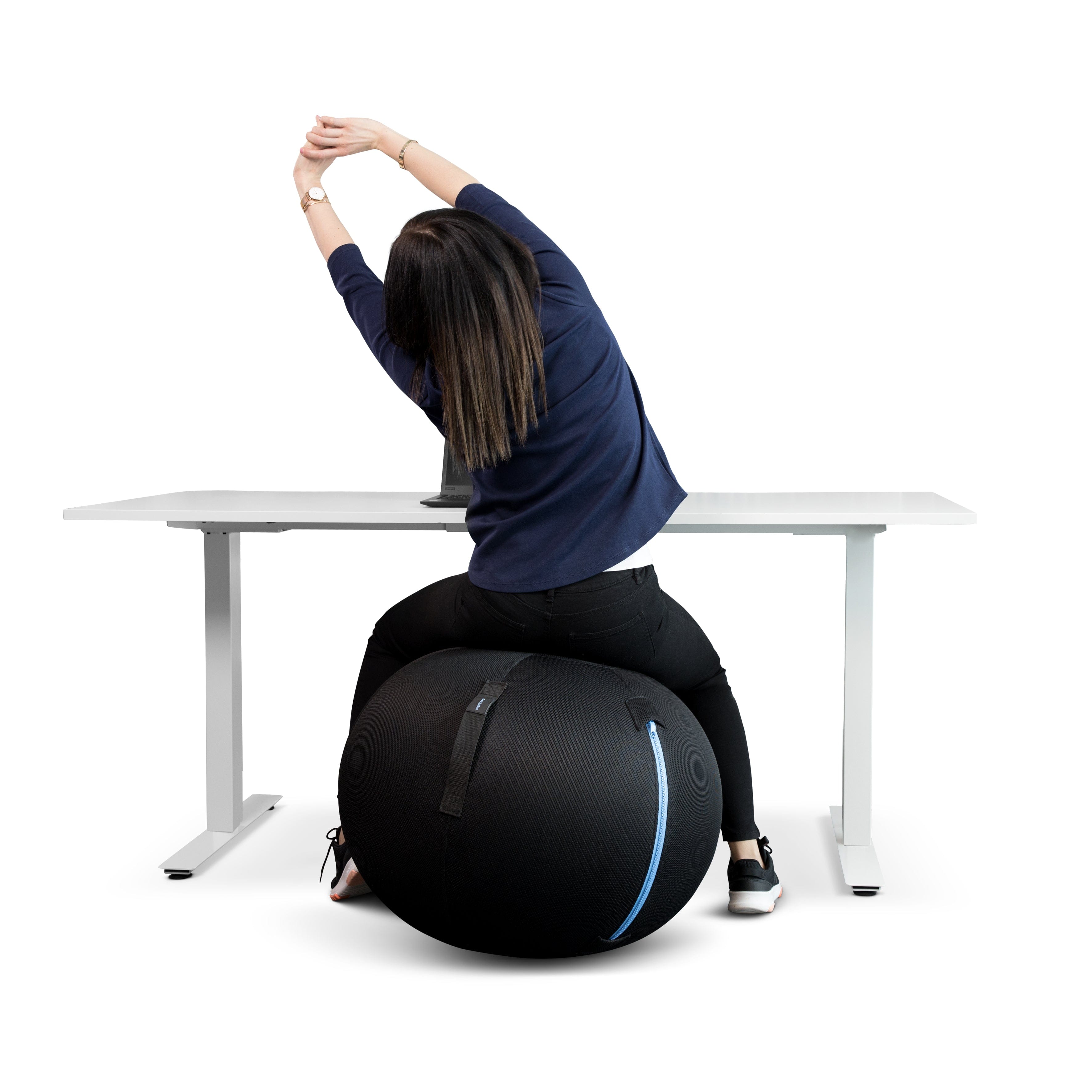 Woman stretching on a black GetUpBall office ball at a desk, promoting core strength and improved posture.