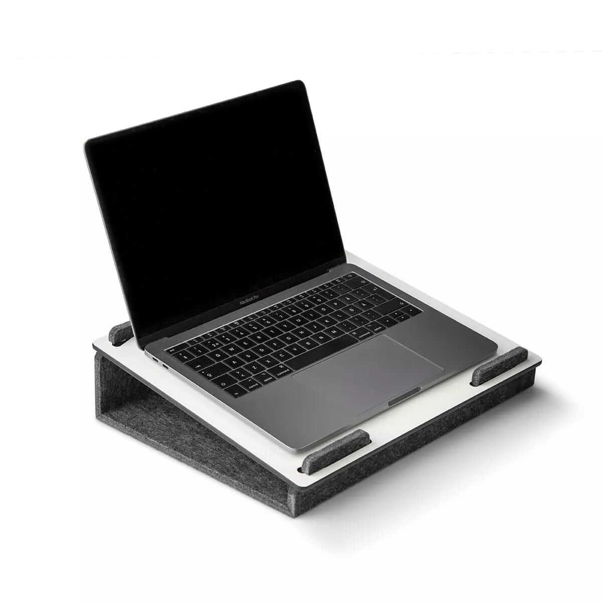 White Läpsteri laptop stand elevating a laptop, showcasing ergonomic design for improved productivity at home or office.