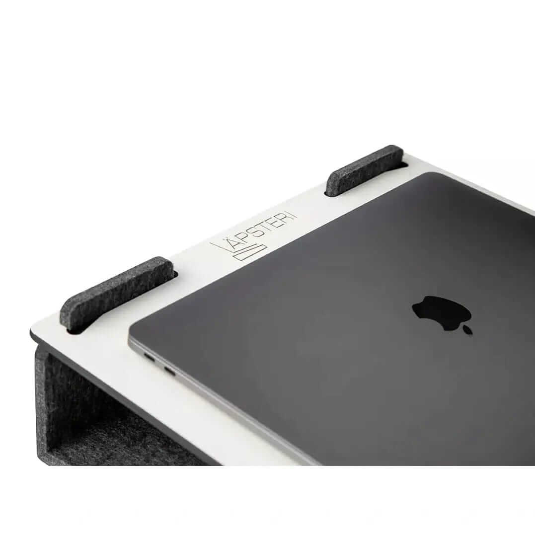 Läpsteri white laptop stand with MacBook, ergonomic desk solution for home, office, and shared workspaces.